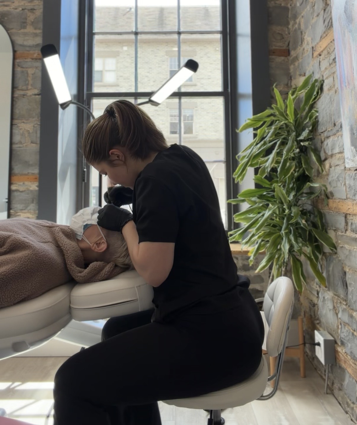 Hannah working with a client during a nano brow appointment